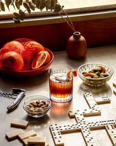 a crossword game with oranges, nuts and other items on the table next to it