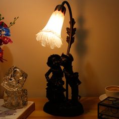 a lamp that is on top of a table next to some ice cubes and flowers