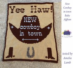 a brown and white afghan with the words ye haw new cowboy in town on it