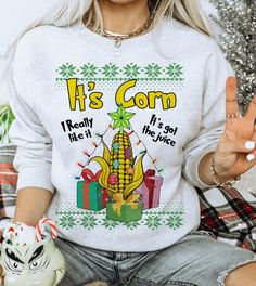 a woman wearing a sweater that says it's corn really like it