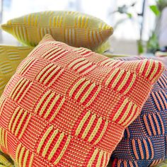 three colorful pillows sitting on top of each other