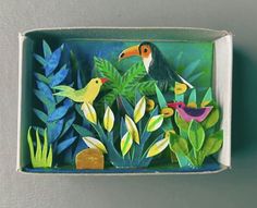 a box with some birds and plants in it