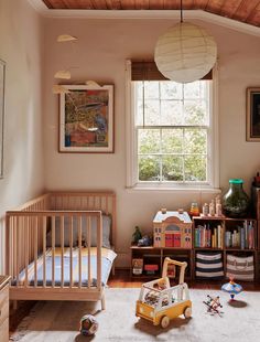 a child's room with toys and bookshelves on the floor in front of a window