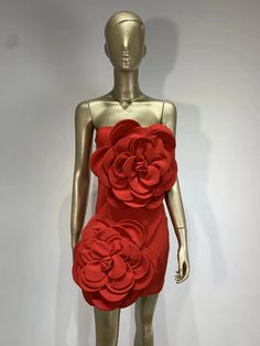 a mannequin wearing a red dress with large flowers on it's back