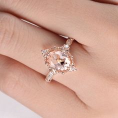 a woman's hand with a ring on it and an oval morganite in the center