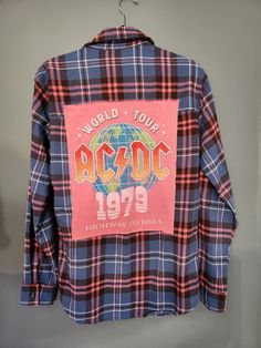 Handmade, hand bleached (optional), reworked flannel with ACDC t-shirt patch on back.  Size women's Small. This item is one of a kind.  Ready to ship!   The materials used for reworked clothing vary (new, used, thrifted, vintage, etc).  All items are freshly washed and dried.     If you like this shirt but have a different idea or theme for the back, message me!  I would love to create something special for you! No returns or exchanges accepted. (I am not affiliated, sponsored, or endorsed by any company or trademark on my upcycled clothing.) Fall Festival Cotton Shirt, Cotton Festival Shirt For Fall, Vintage Long Sleeve Graphic Print Flannel Shirt, Reworked Cotton Long Sleeve Shirt, Vintage Plaid Flannel Shirt With Graphic Print, Acid Wash Bleached Cotton Shirt, Vintage Plaid Tops With Graphic Print, Vintage Cotton Flannel Shirt For Streetwear, Casual Flannel Shirt With Graphic Print