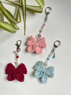 three crocheted butterfly key chains on a table