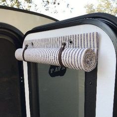 the inside of a train car with its door open and rolled up curtains hanging from it's side