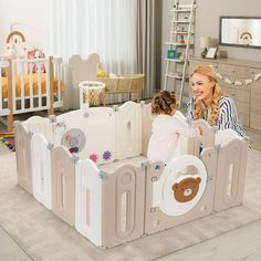 a woman and her child are playing in a playpen with teddy bears on it