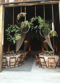 an open barn door with tables and chairs set up for a wedding reception in front of it