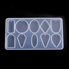 an ice tray with several different shapes and sizes on it, sitting on a black surface