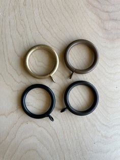 three black and silver rings sitting on top of a wooden table