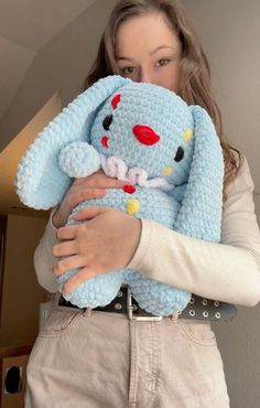 a woman holding a blue stuffed animal in her arms