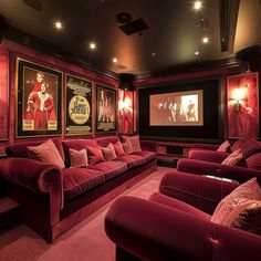 a home theater with red velvet couches and movie posters on the wall behind it