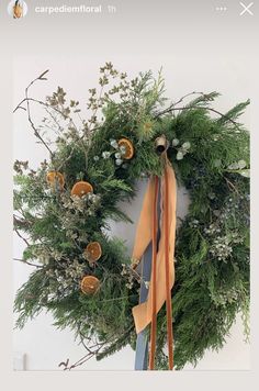 a wreath with an orange ribbon hanging from it