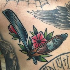 a man's chest with tattoos on it and a knife in the middle of his stomach