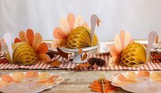 a table topped with plates covered in paper turkeys