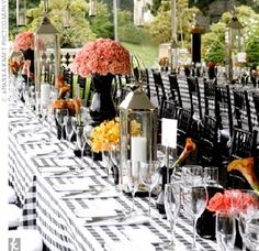 a long table with black and white checkered cloths, vases filled with flowers