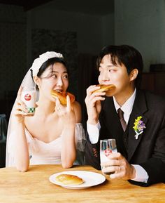 two people sitting at a table eating food