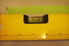 a large yellow ruler with a green handle