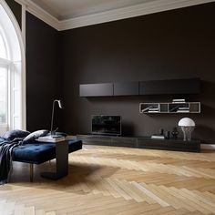 a living room filled with furniture and a large window next to a wall mounted tv