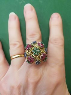 "Beautiful, unique, outrageous vintage18K multi stone ring. There is no karat stamp, but has been tested as 18K. It weighs 14.8 grams, and is set with the following approximate weights of stones: .30 ctw genuine emeralds, .59 ctw genuine sapphires, and .70 ctw genuine rubies. It is between a size 7 1/2 and 8. It has \"bumps\" inside the ring which leave a small gap, when measuring it in a mandrel. There is one flaw in the ring. There is a missing emerald, due to a broken prong. I have this area Luxury Multi-stone Cluster Ring, Elegant Multicolor Multi-stone Ruby Ring, Multicolor Multi-stone Emerald Oval Ring, Multicolor Ruby Ring For Formal Occasions, Exquisite Multicolor Multi-stone Rings, Multicolor Cluster Jewelry For Formal Occasions, Vintage Multi-stone Round Emerald Ring, Vintage Multi-stone Emerald Ring, Unique Multi-stone Emerald Ring For Formal Occasions