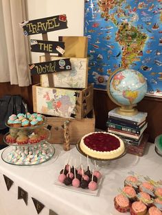 a table topped with cakes and cupcakes next to a map