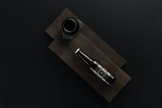 a fountain pen and ink bottle sitting on top of a piece of paper next to a cup of coffee