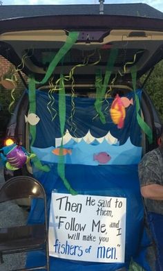 the back end of a car decorated with fish and men's names on it