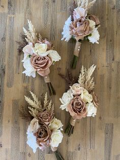 three bouquets of flowers sitting on top of a wooden floor