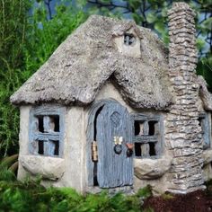 a small house made out of stone with a thatched roof