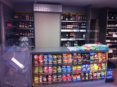 a store filled with lots of different types of drinks and snacks on display in front of the counter