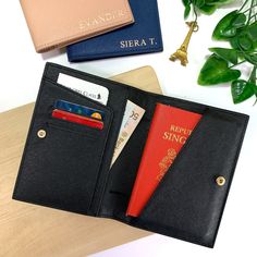 there is a passport case that has two passports in it and an id card holder next to it