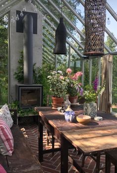 a table and chairs in a room with an open glass roof over looking the garden