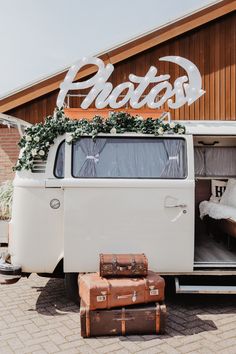 an old vw bus is parked in front of a building with luggage on the ground