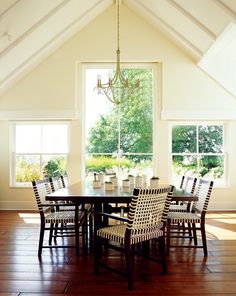 a dining room table with chairs and a chandelier hanging from the ceiling