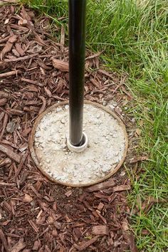 a metal pole is in the middle of some mulch