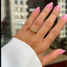 a woman's hand with pink manicures and a gold ring