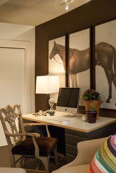 a room with a desk, chair and pictures on the wall above it that have horses painted on them