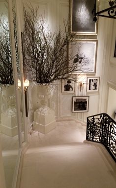 the hallway is decorated in white and black with pictures on the wall, framed by wrought iron railings