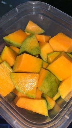 a plastic container filled with cut up pieces of melon and avocado fruit