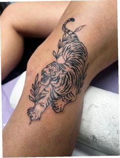 a black and white tiger tattoo on the leg