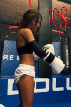 a woman wearing white shorts and boxing gloves