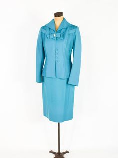 "~ 1950s Gorgeous turquoise blue wool crepe suit ~ This beautiful suit was my Mother's and only worn a few times. ~ Remembering Mom fondly as I'm finally ready to let the suit go ~ Matching decorative bow with rhinestones ~ Both front sides have sewn down pleats ~ Interesting collar & fitted waist ~ 4 covered buttons ~ Jacket has blue silk crepe lining ~ Skirt is half lined in taffeta ~ 7\" side metal zipper ~ Excellent Label: Lilli Ann, Luxurious Fabric of Paris, Loomed in Paris Jacket Bust Fitted Vintage Blue Suits, Vintage Fitted Blue Suits, Blue Fitted Vintage Suit, Vintage Blue Skirt Suit For Formal Occasions, Fitted Vintage Blue Set, Blue Fitted Vintage Set, Vintage Blue Semi-formal Suits, Retro Fitted Blue Sets, Retro Blue Fitted Sets