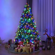 a brightly lit christmas tree with presents under it