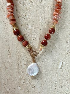 Sunstone Necklace featuring sunstone chips accented with 12MM goldstone beads, gold over copper Bali style bead caps, Swarovski crystals, gold filled toggle clasp and a coin pearl pendant.  Necklace is handmade and measures 18 inches. Sunstone is a sacral chakra stone known for it's leadership, Optimism, and vitality properties. GIFT BOXED Healing Sunstone Gemstone Beads Jewelry, Sacral Chakra Stones, Bali Style, Bali Fashion, Toggle Necklace, Coin Pearls, Handcrafted Artisan Jewelry, Classy Jewelry, Beaded Necklaces