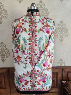 Kashmiri Jacket, Embroidered Coat, Floral Spring Jacket Get Customizable Kashmiri Jacket Wil Multi-colour Embroidery  A Short Woolen Kashmiri Jacket with All Over Multicolour Aari Embroidery (Front & Back) This Kashmiri jacket Makes you stand apart with its vivid colours and Floral embroidery, The base colour is White and Multicolor Aari Embroidery is done all over the jacket, the material used is of high-quality Pure wool and the embroidery is done by brilliant Kashmiri artisans. Embroidery Long Sleeve Nehru Jacket With Intricate Embroidery For Spring, Spring Nehru Jacket With Intricate Embroidery And Long Sleeves, Multicolor Long Sleeve Outerwear With Floral Embroidery, Multicolor Floral Embroidered Long Sleeve Outerwear, White Embroidered Nehru Jacket For Spring, White Embroidered Outerwear For Fall, Spring Outerwear With Resham Embroidery, Fitted Multicolor Outerwear With Intricate Embroidery, Spring White Embroidered Nehru Jacket