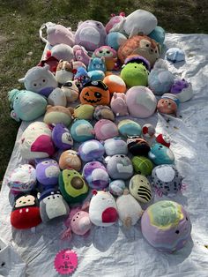 a pile of stuffed animals sitting on top of a blanket