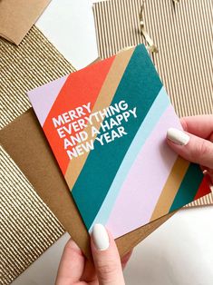 a person holding a card with the words merry everything and happy new year on it