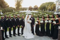 a bride and groom with their bridal party in front of a formal garden setting